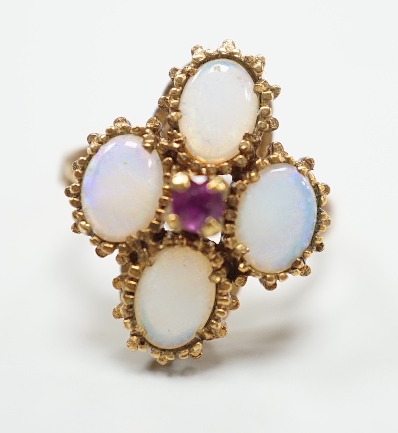 A 1970's 9ct gold, four stone white opal and single stone ruby cluster set dress ring, size O, gross weight 5.2 grams.